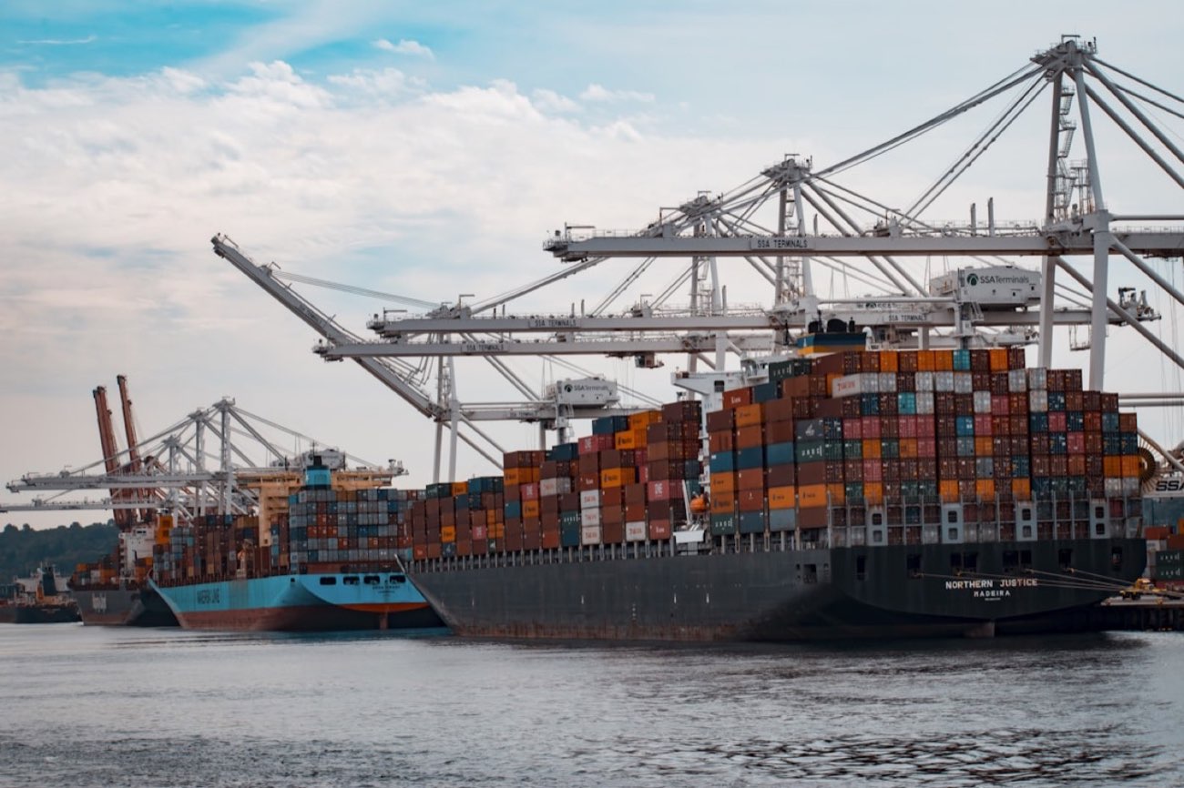 Container ships being loaded by gantry cranes at a port terminal